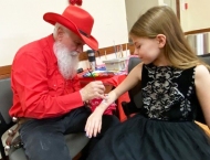 girl in black dress getting arm painted at Dobson Ranch 2019 Breakfast with Santa event