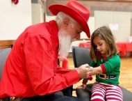 girl in holiday outfit getting arm painted at Dobson Ranch 2019 Breakfast with Santa event