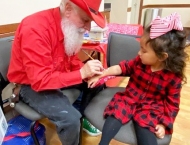 girl in red and black checks getting arm painted at Dobson Ranch 2019 Breakfast with Santa event