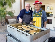 two retired men flipping pancakes at Dobson Ranch 2019 Breakfast with Santa event