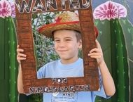boy in cowboy hat peers through frame  at Dobson Ranch 2020 Preschool Graduation event