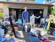man standing inmiddle of his garage sale items at Dobson Ranch 2020 Spring Community Clean Up event