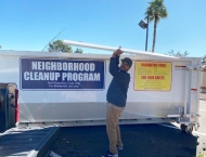 resident tossing items into large dumpster at Dobson Ranch 2020 Spring Community Clean Up event