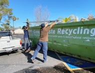 residents tossing recycling items into dumpster at Dobson Ranch 2020 Spring Community Clean Up event