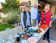 two women stand with garage sale items at Dobson Ranch 2020 Spring Community Clean Up event
