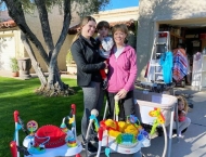 two women and child behind garage sale items at Dobson Ranch 2020 Spring Community Clean Up event