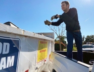 resident tossing items into dumpster at Dobson Ranch 2020 Spring Community Clean Up event