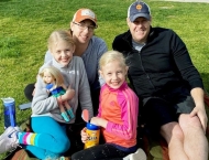 Mom, dad and two young girls sitting on blanket in park  at Dobson Ranch 2020 Sunday in the Park event