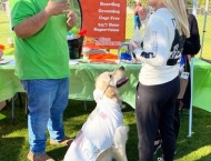 residents by vendor booth with dog at Dobson Ranch 2020 Winter Bark in the Park event