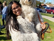 girl in hairy white coat holding hairy white dog at Dobson Ranch 2020 Winter Bark in the Park event